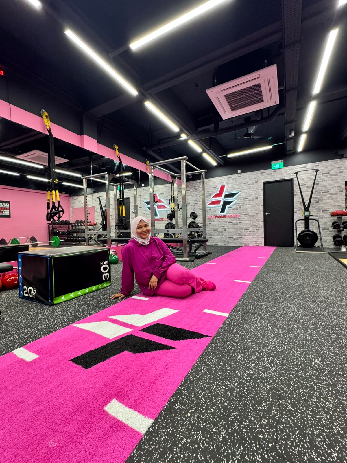 Haslinda Ali seated confidently on the pink runway inside FitFab.sg