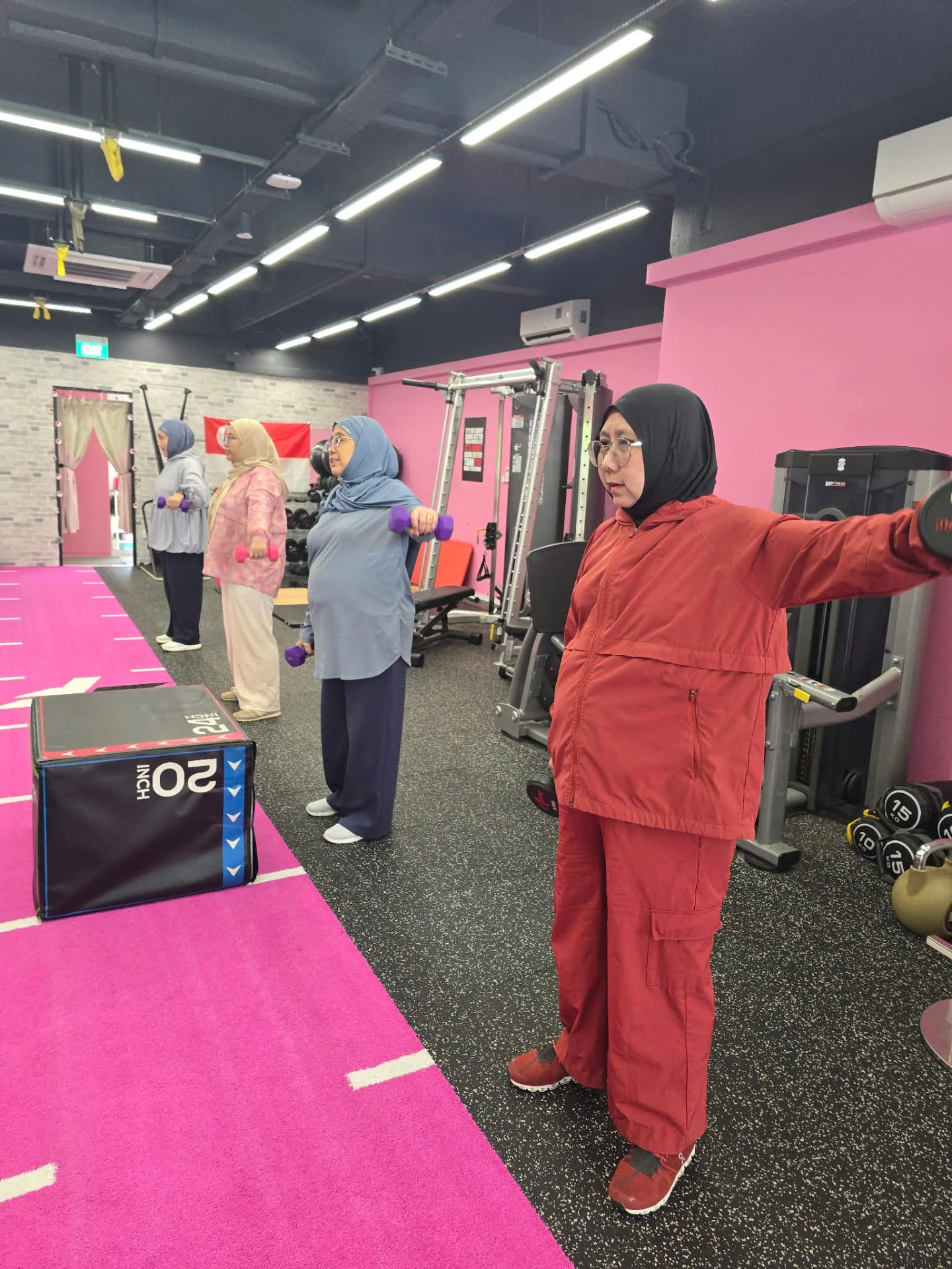 Women training with dumbbells during a FitFab.sg group class